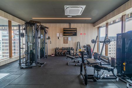 Apartamento à venda com 28m², 1 quarto e sem vagaGinásio com equipamentos de treino e televisão, com vista para a cidade.