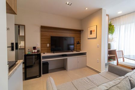 Apartamento à venda com 28m², 1 quarto e sem vagaSala com sofá, TV e mesa de centro, iluminada por lâmpadas e com vista para a cozinha.