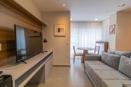 Sala de estar com sofá, TV e mesa redonda, iluminada por luz natural e artificial. de apartamento à venda com 1 quarto, 28m² em Vila Nova Conceição, São Paulo