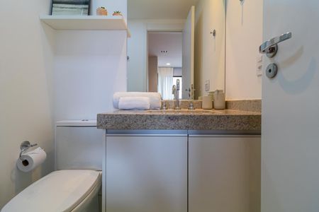 Apartamento à venda com 28m², 1 quarto e sem vagaBanheiro com piso de porcelanato e bancada de granito, com armários e espelho.