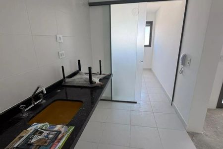 Apartamento à venda com 92m², 3 quartos e 2 vagasCozinha com pia e fogão, com móveis de madeira e azulejos brancos.