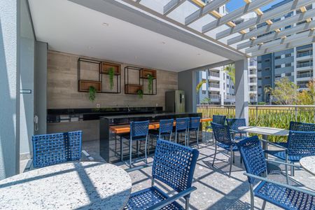 Apartamento à venda com 69m², 2 quartos e 1 vagaVaranda com mesa e cadeiras azuis, com vista para o prédio ao fundo.