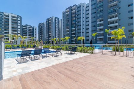 Apartamento à venda com 69m², 2 quartos e 1 vagaPiscina com cadeiras e varanda em um complexo de apartamentos moderno.