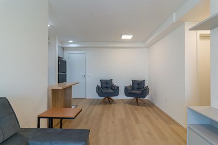 Sala com sofá, mesas e cadeiras, iluminada por luzes de teto e com uma porta para a cozinha. de apartamento à venda com 2 quartos, 69m² em City América, São Paulo