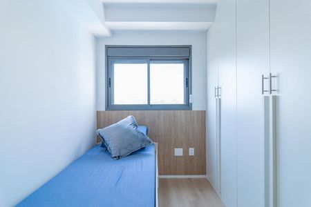 Apartamento à venda com 69m², 2 quartos e 1 vagaCama simples com colchão azul e travesseiro, com vista para a janela e armários brancos.