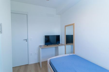 Apartamento à venda com 69m², 2 quartos e 1 vagaQuarto simples com cama de solteiro, TV e porta de vidro.