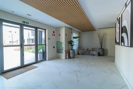 Apartamento à venda com 69m², 2 quartos e 1 vagaPátio com entrada de vidro e porta de vidro, com piso de porcelanato e parede branca, com duas cadeiras e uma planta, com iluminação boa e nível de decoração básico.