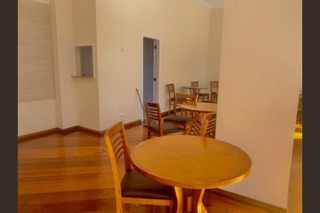 Apartamento à venda com 105m², 3 quartos e 2 vagasSala com mesa redonda e cadeiras de madeira, com piso de madeira e parede branca.