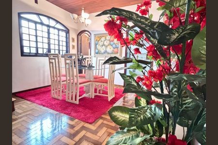 Casa à venda com 170m², 4 quartos e 5 vagasSala de jantar com mesa de vidro e cadeiras brancas e vermelhas, com um tapete vermelho e uma planta com flores vermelhas na frente.