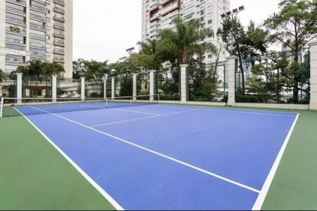 Apartamento à venda com 205m², 4 quartos e 4 vagasTennis court com quadras azuis e verde, cercado por uma cerca de arame e árvores ao fundo.