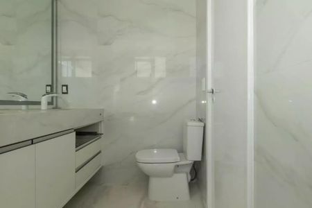 Apartamento à venda com 205m², 4 quartos e 4 vagasBanheiro com piso de porcelanato, vaso sanitário e lavabo brancos, e espelho grande na parede.