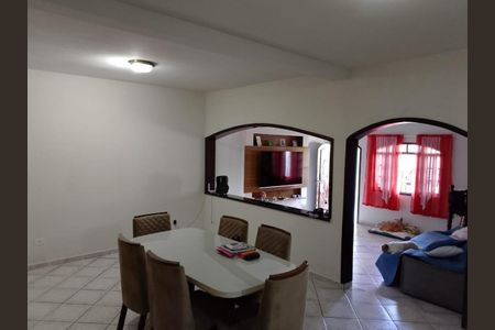 Sala com mesa de jantar, TV e sofá, com vista para a cozinha e janelas com cortinas vermelhas. de casa à venda com 3 quartos, 161m² em Jardim Aida, Guarulhos
