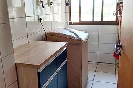 Apartamento à venda com 92m², 3 quartos e 2 vagasCozinha com móveis de madeira e azulejos brancos, com uma janela e uma porta de madeira.