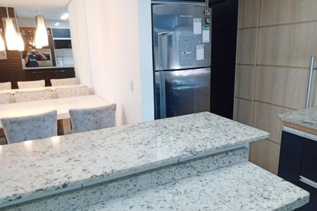 Apartamento à venda com 92m², 3 quartos e 2 vagasCozinha com geladeira, pia e bancada de granito, iluminada por lâmpadas de design.