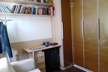 Apartamento à venda com 92m², 3 quartos e 2 vagasEscritório com móveis de madeira e prateleiras de livros, iluminado por luz natural.