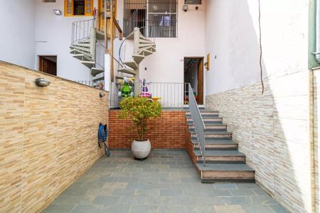 Casa à venda com 130m², 2 quartos e 4 vagasEscada interna com piso de pedra e parede de tijolos, com uma planta em um vaso na base da escada.