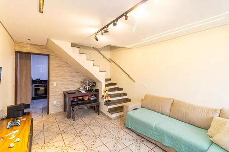 Sala com sofá, mesa e escada, com iluminação adequada e decoração simples. de casa à venda com 2 quartos, 130m² em Vila Medeiros, São Paulo