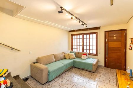 Sala com sofá, mesa e porta de madeira, com iluminação adequada e decoração simples. de casa à venda com 2 quartos, 130m² em Vila Medeiros, São Paulo