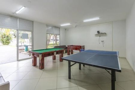 Apartamento à venda com 60m², 2 quartos e 2 vagasSala de jogos com mesa de bilhar, mesa de ping-pong e sofá, com vista para o jardim.