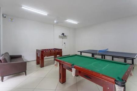 Apartamento à venda com 60m², 2 quartos e 2 vagasSala de jogos com mesa de bilhar, mesa de ping-pong e mesa de futebol, com sofá e iluminação adequada.