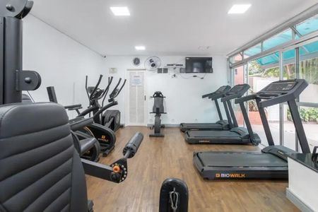 Apartamento à venda com 60m², 2 quartos e 2 vagasSala de ginástica com equipamentos de treino e televisão.
