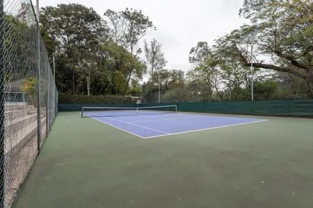 Apartamento à venda com 60m², 2 quartos e 2 vagasTennis court com quadras de tênis e rede, cercado por arame farpado e cercas de arame farpado.