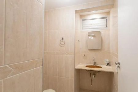 Apartamento à venda com 60m², 2 quartos e 2 vagasBanheiro com piso de porcelanato, pia e vaso sanitário brancos, e uma janela pequena.