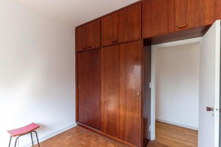 Apartamento à venda com 126m², 3 quartos e 1 vagaCabinete de madeira com gavetas e portas, com uma cadeira vermelha ao lado.