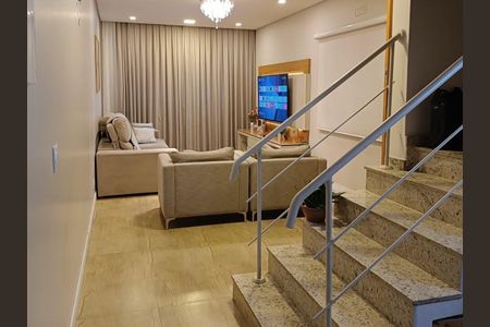 Casa à venda com 150m², 3 quartos e 2 vagasSala de estar com sofás e TV, iluminada por lâmpadas e com cortinas de cor creme.