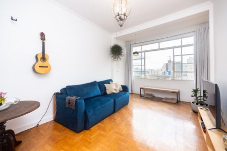 Sala de estar com sofá azul e mesa redonda, com vista para a cidade. de apartamento à venda com 2 quartos, 100m² em Santa Cecilia, São Paulo