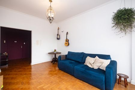 Sala com sofá azul e móveis de madeira, com vista para a cidade. de apartamento à venda com 2 quartos, 100m² em Santa Cecilia, São Paulo