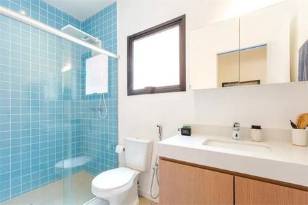 Casa à venda com 168m², 3 quartos e 1 vagaBanheiro com chuveiro e pia branca, com azulejos azuis e madeira na pia e no chão.