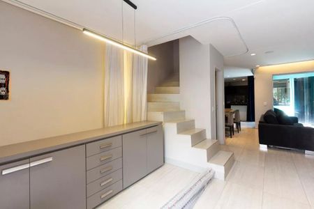 Casa à venda com 147m², 3 quartos e 2 vagasCasa com cozinha moderna e iluminada, com móveis de cor cinza e branco, e uma escada branca.