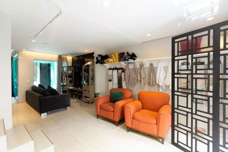 Sala com dois sofás e duas poltronas, com uma parede de vidro e uma porta de vidro. de casa à venda com 3 quartos, 147m² em Vila Olímpia, São Paulo