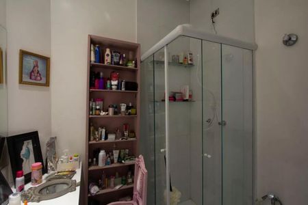 Casa à venda com 147m², 3 quartos e 2 vagasBanheiro feminino com prateleira de produtos de higiene e decoração em tons de rosa e branco.
