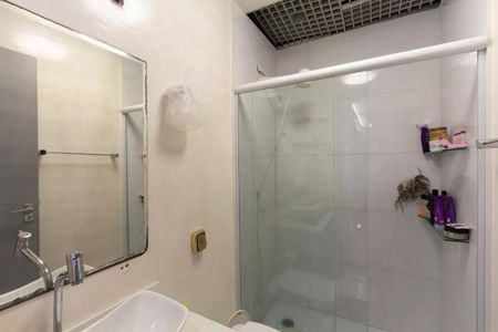 Casa à venda com 147m², 3 quartos e 2 vagasBanheiro com chuveiro, pia e espelho, com uma planta no canto e produtos de higiene ao lado do chuveiro.