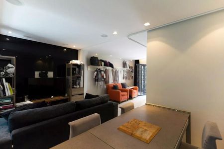 Sala com sofás, mesas e televisão, com iluminação adequada e decoração simples. de casa à venda com 3 quartos, 147m² em Vila Olímpia, São Paulo