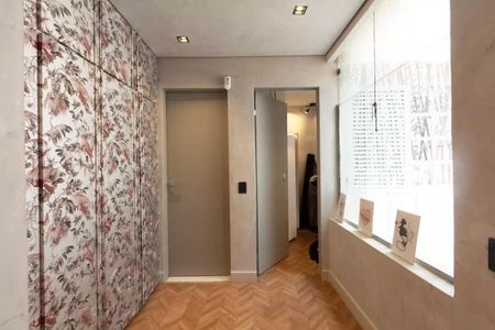 Casa à venda com 147m², 3 quartos e 2 vagasParede com decoração floral e porta de correr, com iluminação adequada e piso de madeira.