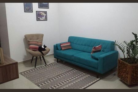 Apartamento à venda com 85m², 3 quartos e sem vagaCãmara de estar com sofá de cor verde, cadeira e gato, com plantas e quadros na parede.