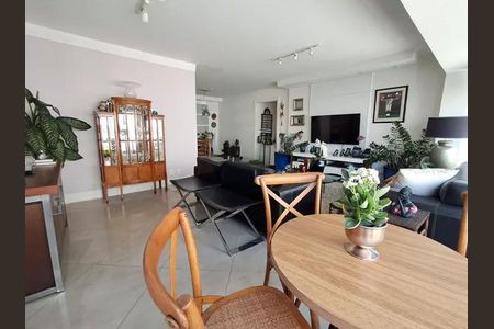 Apartamento à venda com 140m², 3 quartos e 4 vagasSala com mesa redonda, cadeiras de madeira e TV na parede, com decoração simples e plantas.