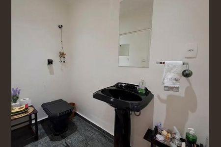 Apartamento à venda com 140m², 3 quartos e 4 vagasBanheiro com pia preta e espelho, com um toalheiro branco e um sabonete verde.