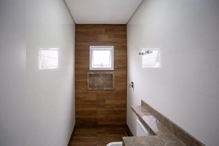 Casa à venda com 183m², 3 quartos e 4 vagasBanheiro com piso de madeira e pia de granito, com uma janela pequena e iluminação boa.