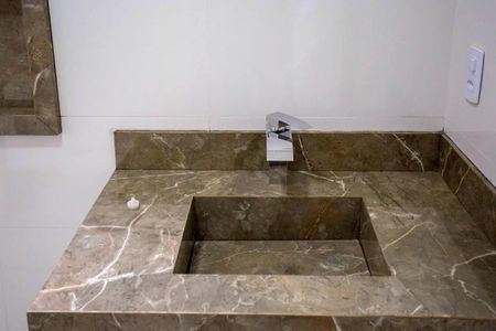 Casa à venda com 183m², 3 quartos e 4 vagasBanheiro com pia e vaso sanitário em mármore e azulejos de cores escuras e claras.