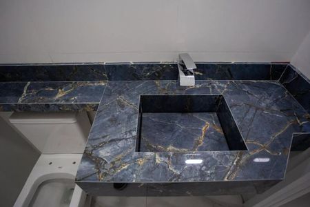 Casa à venda com 183m², 3 quartos e 4 vagasBanheiro com pia e vaso sanitário em mármore azul com veios dourados, com iluminação boa e nenhuma decoração.