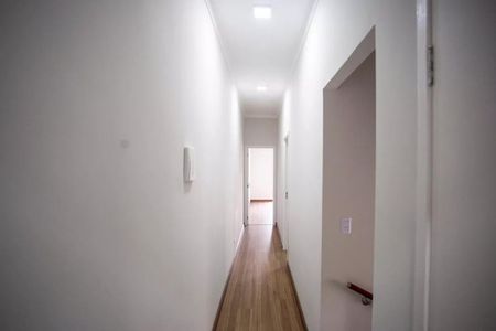 Casa à venda com 183m², 3 quartos e 4 vagasParede branca e longa, com uma porta no final e uma luz acima.