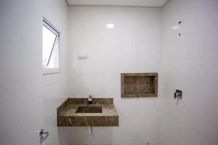 Casa à venda com 183m², 3 quartos e 4 vagasBanheiro com pia e vaso sanitário, com teto branco e paredes brancas, com uma janela pequena e uma porta de vidro.