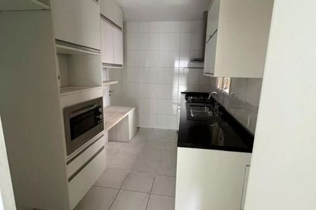 Apartamento à venda com 125m², 3 quartos e 2 vagasCozinha com móveis brancos e azulejos brancos, com uma bancada de granito e um fogão.