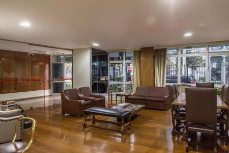 Apartamento à venda com 85m², 2 quartos e sem vagaSala de estar com móveis de couro e madeira, iluminada por luz natural e artificial, com vista para a rua.