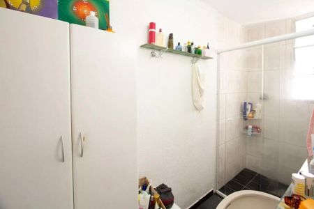 Apartamento à venda com 85m², 2 quartos e sem vagaBanheiro com chuveiro, pia e armários brancos, com pinturas coloridas no teto.