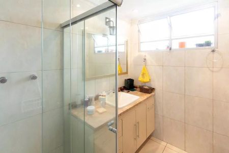 Apartamento à venda com 85m², 2 quartos e sem vagaBanheiro com pia e chuveiro, com uma janela pequena e iluminação boa.